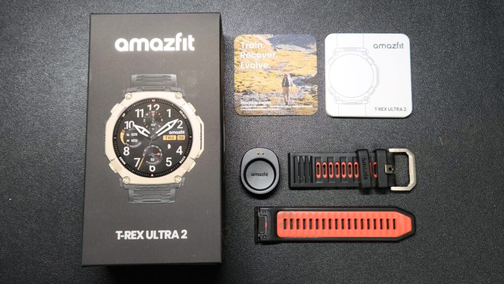 同梱物：スマートウォッチ本体 (標準ストラップ付), 充電器 (ヘッド部分のみ), 取扱説明書